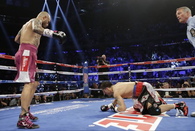 Miguel Cotto, of Puerto Rico, knocks down Sergio Martinez, of Argentina, during the first round of a WBC World Middleweight Title boxing match Saturday, June 7, 2014, in New York. Cotto won the fight. (AP Photo/Frank Franklin II)