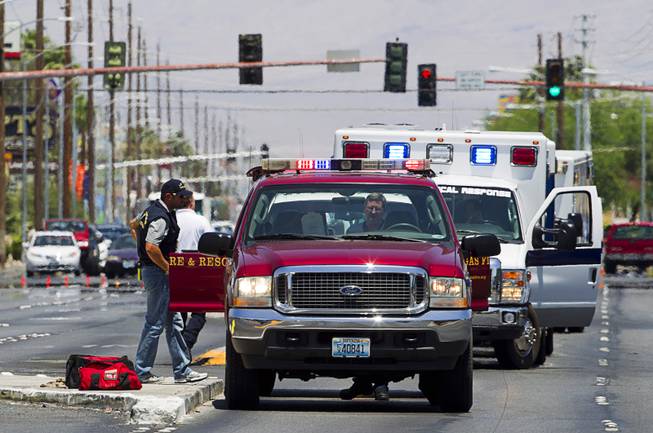 Ambulances and rescue units stage on Nellis Boulevard Sunday, June 8, 2014. Two suspects shot two Metro Police officers in a nearby pizza shop then fled to the Wal-Mart where they shot and killed another person, police said. Both officers died of their injuries.