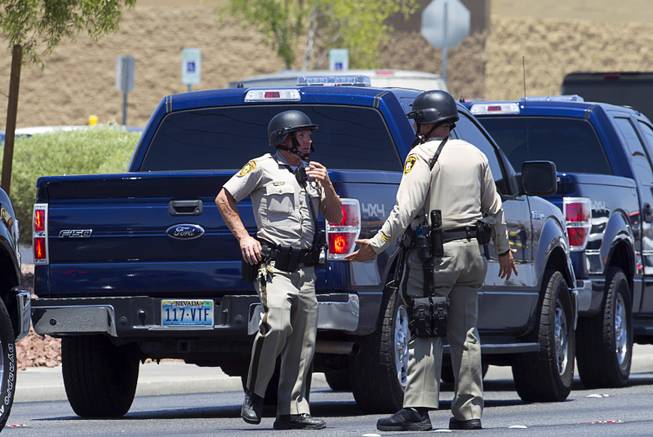 Metro Police officers confer outside a Wal-Mart on Nellis Boulevard Sunday, June 8, 2014. Two suspects shot two Metro Police officers in a nearby pizza shop then fled to the Wal-Mart where they shot and killed another person, police said. Both officers died of their injuries.