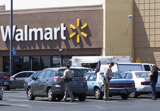 Metro Police officers look over vehicles in the Wal-Mart on Nellis Boulevard Sunday, June 8, 2014. Two suspects shot two Metro Police officers in a nearby pizza shop then fled to the Wal-Mart where they shot and killed another person, police said. Both officers died of their injuries.