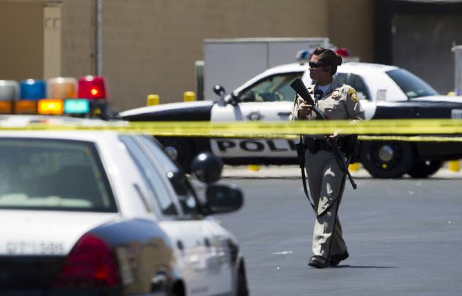 A Metro Police officer is shown behind a Wal-Mart on Nellis Boulevard on Sunday, June 8, 2014. Two suspects allegedly shot two Metro Police officers in a nearby pizza shop, then fled to the Wal-Mart, where they fired shots before killing themselves.