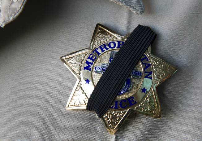 A Metro Police officer wears a ribbon over his badge at Metro headquarters following the death of two officers and a citizen Sunday, June 8, 2014. Two suspects, also dead, shot two Metro Police officers at CiCi's Pizza on Nellis Boulevard, then fled to a nearby Wal-Mart, where they shot and killed another person before killing themselves, police said.