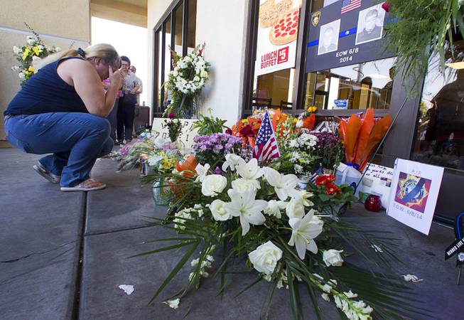 Brenda Williams pays her respects at a memorial in front of CiCi's Pizza, where two Metro Police officers were killed, during a community vigil Monday, June 9, 2014. Police officers Alyn Beck, 41, and Igor Soldo, 31, were ambushed and killed in the restaurant while they were eating lunch on June 8.