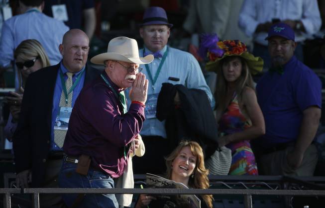 California Chrome co-owner Steve Coburn calls from the grandstand at Belmont Park after his horse finished fourth in the Belmont Stakes horse race, Saturday, June 7, 2014, in Elmont, N.Y.