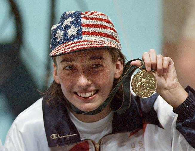 In this July 26, 1996 file photo, Olympic gold medalist Amy Van Dyken holds her medal after winning the women's 50 meter freestyle at the 1996 Summer Olympic Games in Atlanta. Van Dyken has a severed spine after an accident on her all-terrain vehicle in Arizona. 