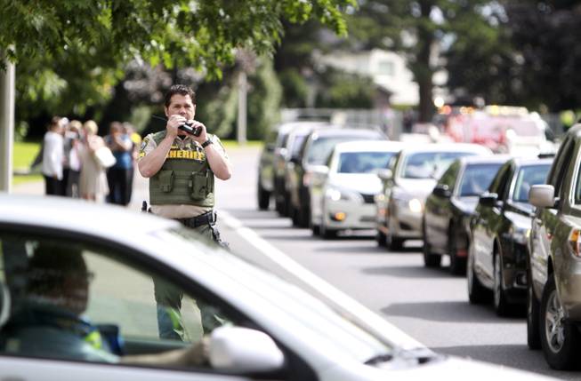 A sheriff's officer speaks in this radio after a shooting at Reynolds High School Tuesday, June 10, 2014, in Troutdale, Ore. A gunman killed a student at the high school east of Portland Tuesday and the shooter is also dead, police said.