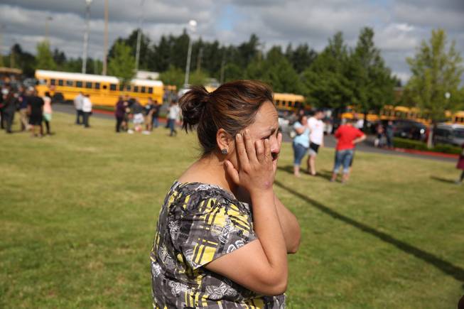 A woman waits to hear about the safety of students after a shooting at Reynolds High School Tuesday, June 10, 2014, in Troutdale, Ore. A gunman killed a student at the high school east of Portland Tuesday and the shooter is also dead, police said.