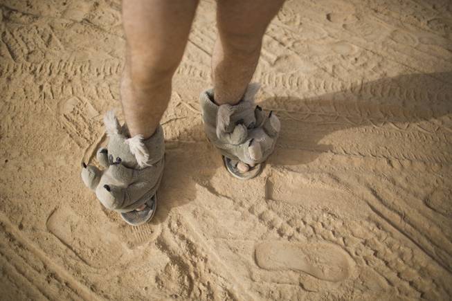 In this photo taken Thursday, June 5, 2014, an Israeli man walks in house slippers during Israelis first Midburn festival in the desert near the Israeli kibbutz of Sde Boker.