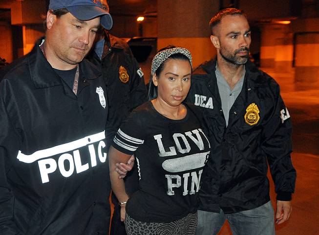 Samantha Barbash, center, is escorted by law enforcement officers following her arrest in New York, Monday, June 9, 2014. Barbash is allegedly part of a crew of New York City strippers who scammed wealthy men. 