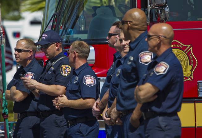 Clark County Firefighters look on as the flag-draped coffin of slain Metro Officer Igor Soldoand procession depart from the Palm Mortuary to the Canyon Ridge Church service on Thursday, June 12, 2014.