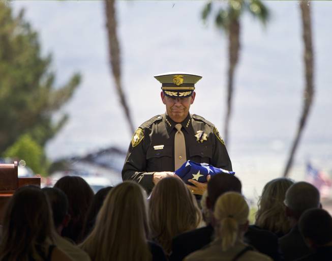 Clark County Sheriff Doug Gillespie carries a folded American flag over to Andrea Soldo, wife of slain Metro Officer Igor Soldo, during funeral services at Palm Mortuary on Thursday, June 12, 2014.
