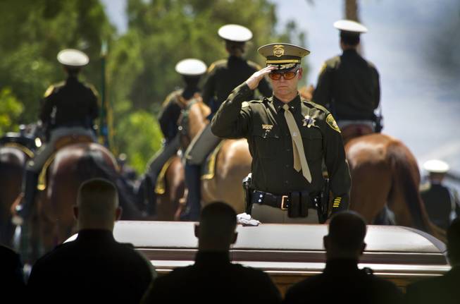 The casket of slain Metro Officer Igor Soldo is saluted by officer after officer ending funeral services at the Palm Mortuary on Thursday, June 12, 2014.