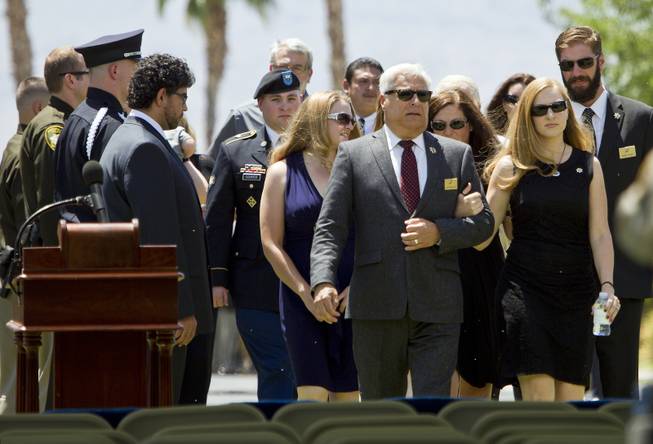 Andrea Soldo and other family members of slain Metro Officer Igor Soldo are led to a covered tent during the start of funeral services at the Palm Mortuary on Thursday, June 12, 2014.