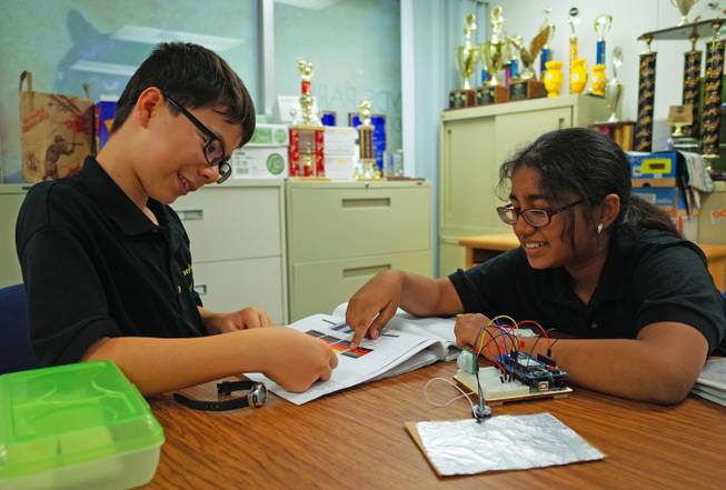 Hyde Park Middle School sixth-graders Craig Hammond, 11, and Pranathi Tallapragada, 11, look over their invention, which alerts parents to children left in unattended cars. The students will represent Nevada in the national eCybermission competition June 20.