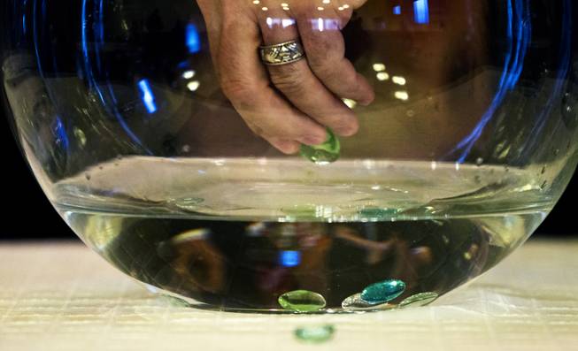 Attendees drop sacred stones into a community bowl during a water ceremony guided by Lisa Franqui of Creekside Hospice at Palm Mortuary on Friday, June 13, 2014. Franqui is a grief/bereavement support expert and spoke with community members about self care and finding hope.