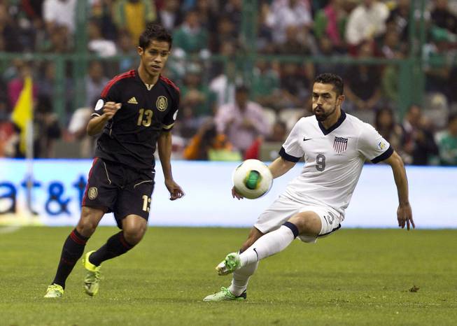 United States' Herculez Gomez, right, and Mexico's  Severo Meza vie for the ball during a 2014 World Cup qualifying match at the Aztec stadium in Mexico City, Tuesday, March 26, 2013. 