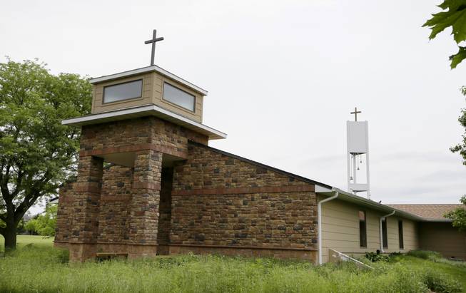 In this June 10, 2014, photo, a cellphone tower inside the bell tower, rear right, is seen over the Resurrection Lutheran Church in Ankeny, Iowa. As wireless companies fill gaps in their networks, many have sought to camouflage the ungainly outdoor equipment that carries the nation’s daily diet of calls, text messages and data.