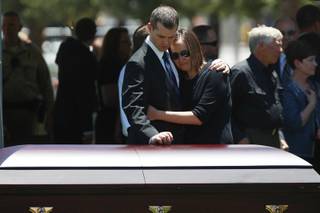 Joseph Beck, left, holds an unidentified woman as they stand over the casket of Beck's brother, Metro officer Alyn Beck during a memorial at The Smith Center for the Performing Arts Saturday, June 14, 2014.