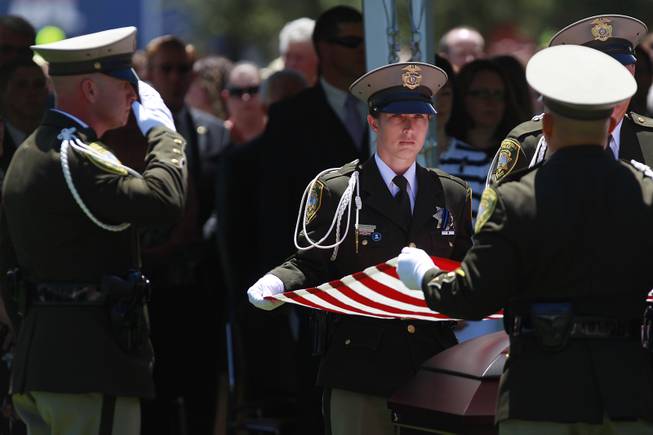 Pallbearers fold the flag from the coffin of Metro officer Alyn Beck during a memorial service Saturday, June 14, 2014 at the Smith Center for the Performing Arts.