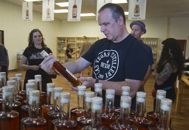 Paul Norman, vice president of Schmooze Brothers Distribution, looks over a bottle of "Nevada 150" bourbon whiskey during "Bourbon Day" at the Las Vegas Distillery in Henderson Saturday, June 14, 2014. The bourbon, the first bourbon produced in Nevada, is named for Nevada's sesquicentennial.