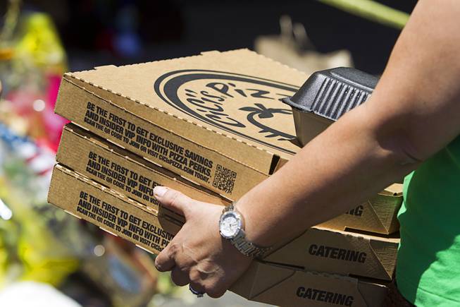 A customer carries out pizza-to-go during "Sharing Our Support," a fundraiser for the families of Metro Police Officers Igor Soldo and Alyn Beck, at CiCi's Pizza Sunday, June 15, 2014. The officers were ambushed and killed at the restaurant while eating lunch on Sunday, June 8. One hundred percent of the Sunday sales will go the families of the fallen officers and Joseph Willcox, the victim killed at the Wal-Mart, said store owner Mike Haskins.