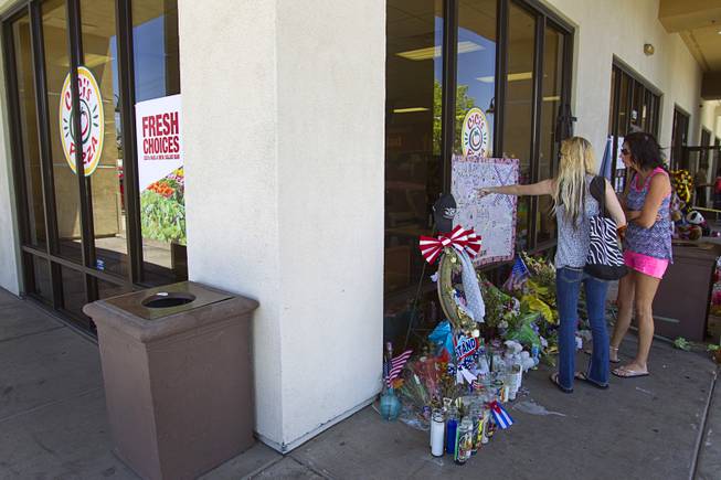 Katie Lynn Coffin, center, and Tanya Akers of Pahrump look over a memorial during "Sharing Our Support," a fundraiser for the families of Metro Police Officers Igor Soldo and Alyn Beck, at CiCi's Pizza Sunday, June 15, 2014. The officers were ambushed and killed at the restaurant while eating lunch on Sunday, June 8. One hundred percent of the Sunday sales will go the families of the fallen officers and Joseph Willcox, the victim killed at the Wal-Mart, said store owner Mike Haskins.