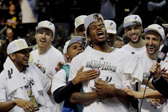Most Valuable Player San Antonio Spurs forward Kawhi Leonard, third from right, celebrates after Game 5 of the NBA basketball finals against the Miami Heat on Sunday, June 15, 2014, in San Antonio. The Spurs won the NBA championship 104-87