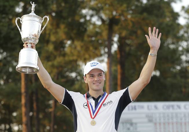 Martin Kaymer of Germany holds up the trophy after wining the U.S. Open golf tournament in Pinehurst, N.C., Sunday, June 15, 2014.