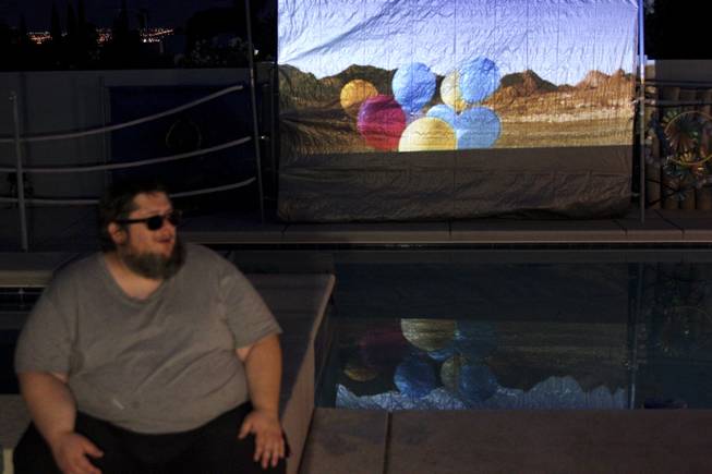 Scott Grow talks about his work while a video of his performance plays in the background during the 2014 London Biennale in Las Vegas, a satellite site for the biennale, Saturday, June 14, 2014.