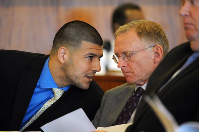 Former New England Patriots football player Aaron Hernandez, left, talks with one of his defense attorneys, Charles Rankin, during a hearing at the Bristol County Superior Court House, Monday, June 16, 2014, in Fall River, Mass.
