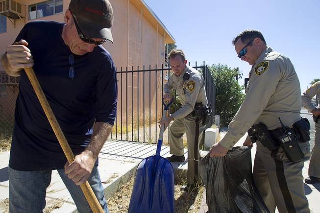 Carl Thompson, left, and Metro Police officers participate in a Downtown Community Coalition neighborhood cleanup near Fremont Street and 21st Street Tuesday, June 17, 2014. A variety of community, church and business groups, along with Metro Police and the City of Las Vegas, participated in the event.