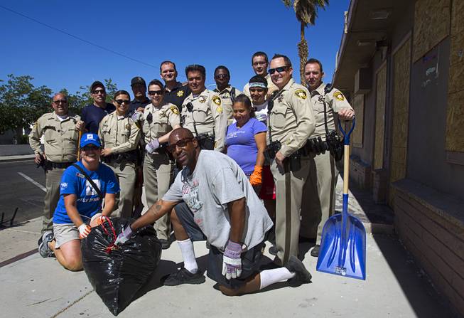 Metro Police officers pose with residents and volunteers during a Downtown Community Coalition neighborhood cleanup near Fremont Street and 21st Street Tuesday, June 17, 2014. A variety of community, church and business groups, along with Metro Police and the City of Las Vegas, participated in the event.