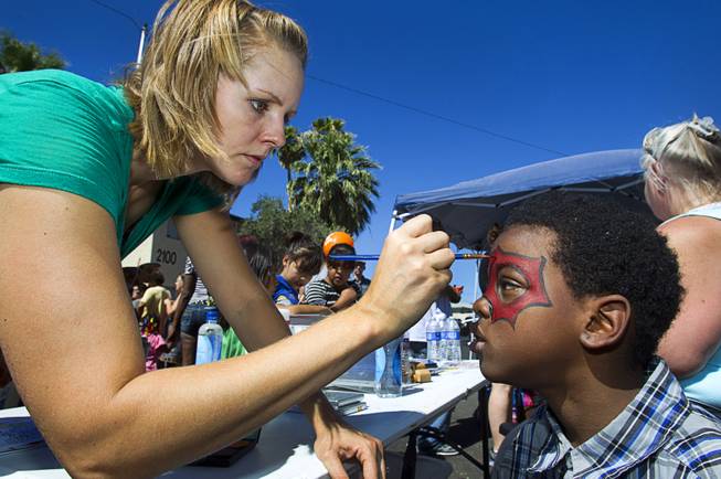 Margaret Nitzel of Verve Church paints the face of Samajay Bright, 8, during a Downtown Community Coalition neighborhood cleanup near Fremont Street and 21st Street Tuesday, June 17, 2014. A variety of community, church and business groups, along with Metro Police and the City of Las Vegas, participated in the event.