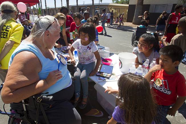 Fern Williams of the Verge church paints faces during a Downtown Community Coalition neighborhood cleanup near Fremont Street and 21st Street Tuesday, June 17, 2014. A variety of community, church and business groups, along with Metro Police and the City of Las Vegas, participated in the event.