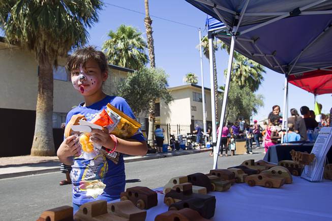 Leslie Diaz, 9, picks up a handmade toy vehicle at the Toys-For-Smiles booth during a Downtown Community Coalition neighborhood cleanup near Fremont Street and 21st Street Tuesday, June 17, 2014. The charity gives away about 3,000 toys per month, said volunteer Chris Meeks. A variety of community, church and business groups, along with Metro Police and the City of Las Vegas, participated in the event.