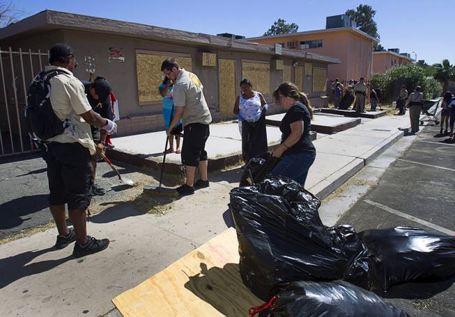 Downtown Rangers, left, and other volunteers assist in a Downtown Community Coalition neighborhood cleanup near Fremont Street and 21st Street Tuesday, June 17, 2014. A variety of community, church and business groups, along with Metro Police and the City of Las Vegas, participated in the event.