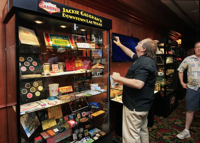 Neal Silverman ensures the display is working during the El Cortez Hotel & Casino premiere of the Jackie Gaughan memorial exhibit titled Jackie Gaughans Downtown as seen through Gaming Memorabilia" on Tuesday, June 17, 2014.  Silverman is a Museum of Gaming History board of director's member and helped to put the display together.