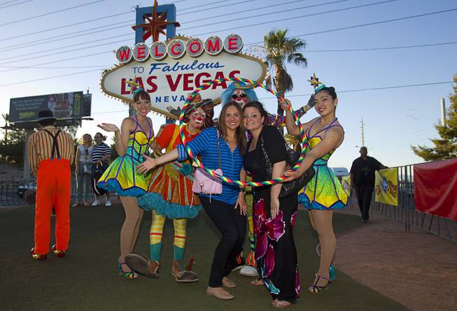 Maya Kobray, left, of New York City, and Dionne Farino of Chicago poses with members of Ringling Bros. and Barnum & Bailey Circus entertain tourists and pose for photographs at the Welcome to Fabulous Las Vegas sign Wednesday, June 18, 2014. The circus performs at Thomas & Mack Center Thursday through Sunday.