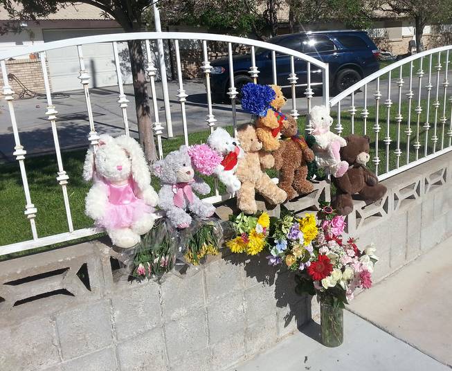 A memorial of stuffed animals and flowers is shown Thursday, June 19, 2014, at the home where two children died in an early-morning fire.
