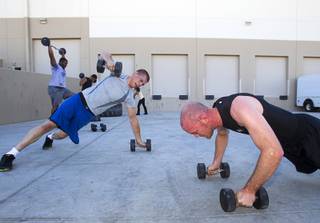 James Chaney, left, and Trevor Hall work out during a MMA bootcamp fitness class at the Syndicate MMA Gym, 6980 W Warm Springs Rd., Thursday, June 19, 2014.