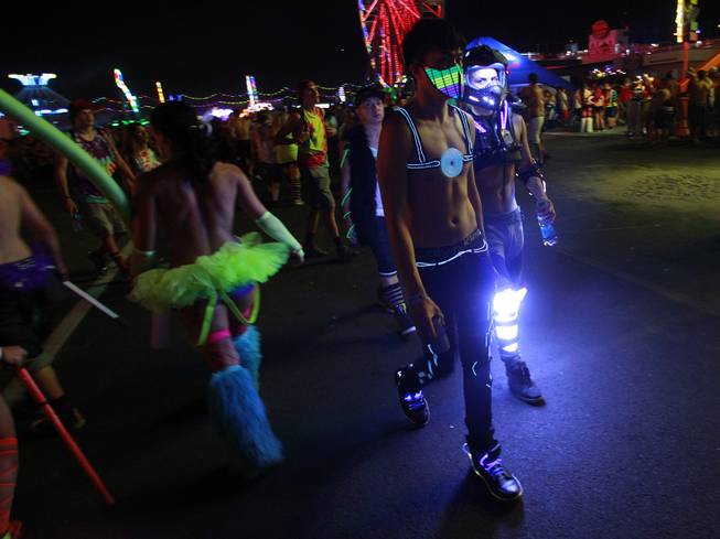 Attendees in costume walk the grounds during the first night of the Electric Daisy Carnival Saturday, June 21, 2014 at the Las Vegas Motor Speedway.