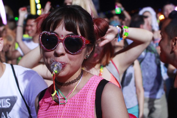 A woman in heart-shaped glasses and sucking on a pacifier is seen during the first night of the Electric Daisy Carnival early Saturday, June 21, 2014, at Las Vegas Motor Speedway.