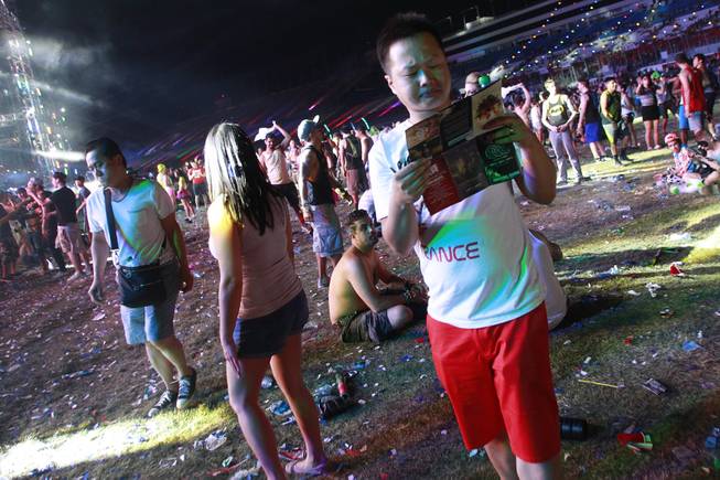 An attendee checks the schedule during the first night of the Electric Daisy Carnival early Saturday, June 21, 2014 at the Las Vegas Motor Speedway.