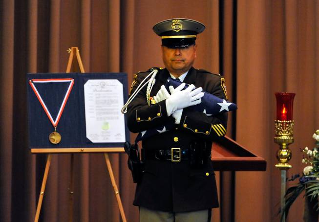 Las Vegas police Lt. Robert Smith of the honor guard presents an American flag during a memorial service for Joseph Wilcox at Palm Downtown Mortuary and Cemetery on Sunday, June 22, 2014. Wilcox, 31, was killed trying to stop Jerad and Amanda Miller in the midst of their shooting spree at an east valley Walmart store on June 8. 