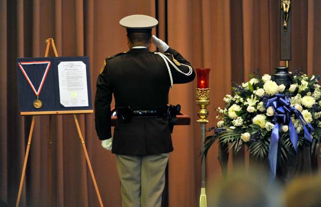 Las Vegas police Lt. Robert Smith of the honor guard salutes an American flag during a memorial service for Joseph Wilcox at Palm Downtown Mortuary and Cemetery on Sunday, June 22, 2014. Wilcox, 31, was killed trying to stop Jerad and Amanda Miller in the midst of their shooting spree at an east valley Walmart store on June 8.