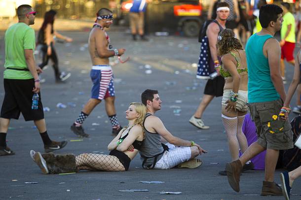 A pair of fans rest against each other before leaving the Las Vegas Motor Speedway after the final night of the 2014 Electric Daisy Carnival (EDC) Sunday, June 22, 2014.