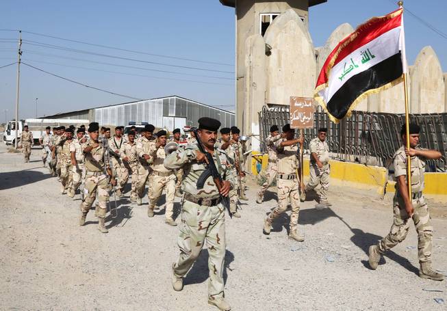 Iraqi army soldiers parade inside the main army recruiting center during a recruiting drive for men to volunteer for military service in Baghdad, Iraq, Thursday, June 19, 2014, after authorities urged Iraqis to help battle insurgents.