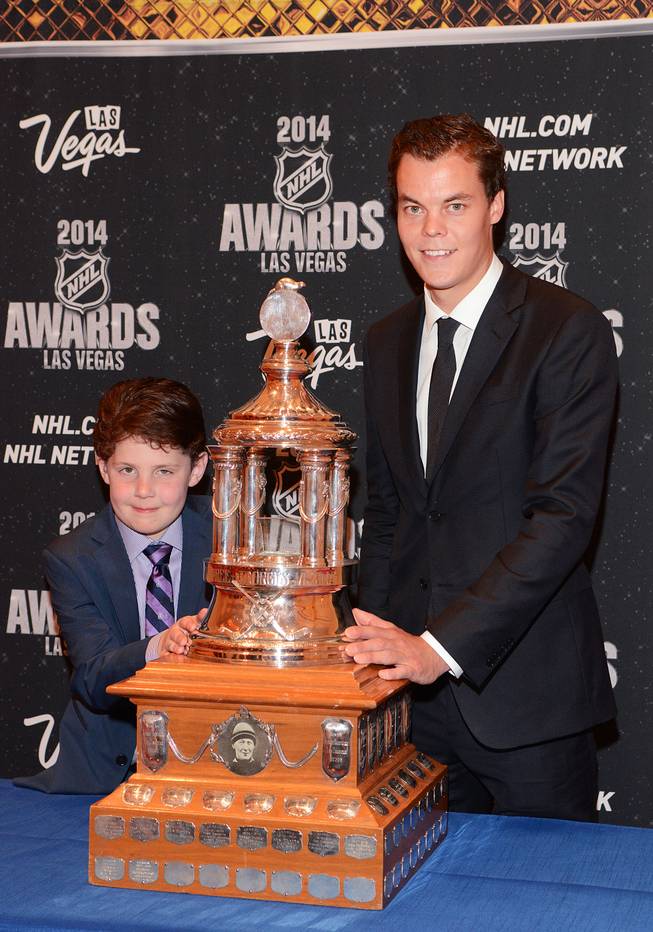 Nine-year-old Will Lacey of Boston, who is battling a brain tumor, and Tuukka Rask of the Boston Bruins with the Vezina Trophy at the 2014 NHL Awards in Encore Theater on Tuesday, June 24, 2014, at Wynn Las Vegas.