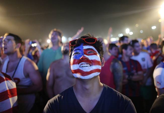 A soccer fan of the U.S. national soccer team watches a live broadcast of the soccer World Cup match between USA and Ghana, inside the FIFA Fan Fest area on Copacabana beach, Rio de Janeiro, Brazil, Monday, June 16, 2014. 