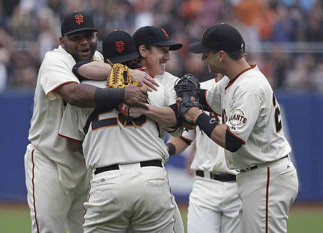 San Francisco Giants pitcher Tim Lincecum, center, is embraced by teammates, from left, Pablo Sandoval, catcher Hector Sanchez, and Buster Posey after throwing a no-hitter against the San Diego Padres, Wednesday, June 25, 2014, in San Francisco. 